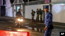 FILE - Maldives soldiers and policemen guard the main street after the government declared a 15-day state of emergency in Male, Maldives, Feb. 6, 2018. 