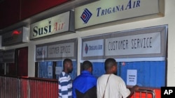 Keluarga penumpang pesawat Trigana Air yang hilang berdiri di depan loket Trigana Air yang tutup di bandara Sentani di Jayapura, Papua, 16 Agustus 2015.