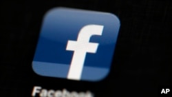 FILE - In this May 16, 2012, file photo, the Facebook logo is displayed on an iPad in Philadelphia. Facebook is adding a “disputed news” flag on stories that have been deemed fake by what Facebook says are third parties,
