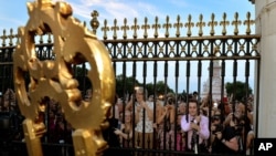 Warga berkerumun di depan Istana Buckingham untuk membaca pengumuman tentang kelahiran Pangeran Kerajaan Inggris, putra pertama Pangeran William dan istrinya Kate, pada jam 4: 24 sore waktu setempat (22/7).