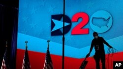 Un trabajador limpia el escenario donde hablarán los oradores en la tercera noche de la Convención Nacional Demócrata, el 19 de agosto de 2020, en Delaware.