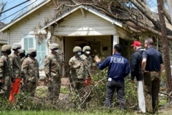 President Donald Trump and Homeland Security Secretary Chad Wolf speak with National Guard soldiers helping with cleanup as they tour damage from Hurricane Laura, Aug. 29, 2020, in Lake Charles, La.