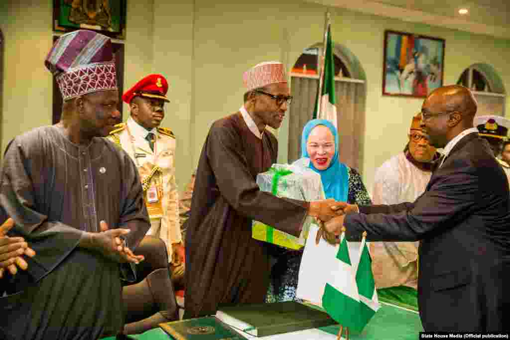 Shugaba Muhammadu Buhari yana bude Cibiyar Ayyukan Shige da Ficen Baki ta Najeriya tare da karamar jakadiya Mrs Uche Ajulu-Okeke da mai rikon mukamin babban jakadan Najeriya a Afirka ta Kudu, Mr. Martins Cobham a lokacin da ya gana da al'ummar Najeriya a karamin ofishin jakadancin Najeriya na Johannesburg a Afirka ta Kudu.