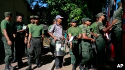 FILE - Seorang pegawai pemerintah Sri Lanka (tengah) bersama dengan tentara bersiap untuk melakukan pemberantasan Demam Berdarah di Colombo, Sri Lanka, July 4, 2017.