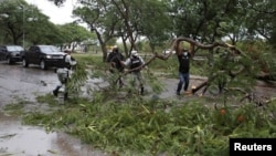Miembros de la Guardia Nacional quitan ramas de árboles de una calle después de que el huracán Grace tocó tierra en la península de Yucatán, en Mérida, México, el 19 de agosto de 2021.