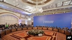 Des délégations de la Russie, de l'Iran et de la Turquie s'entretiennent sur la paix en Syrie dans un hôtel d'Astana, au Kazakhstan, le lundi 23 janvier 2017.