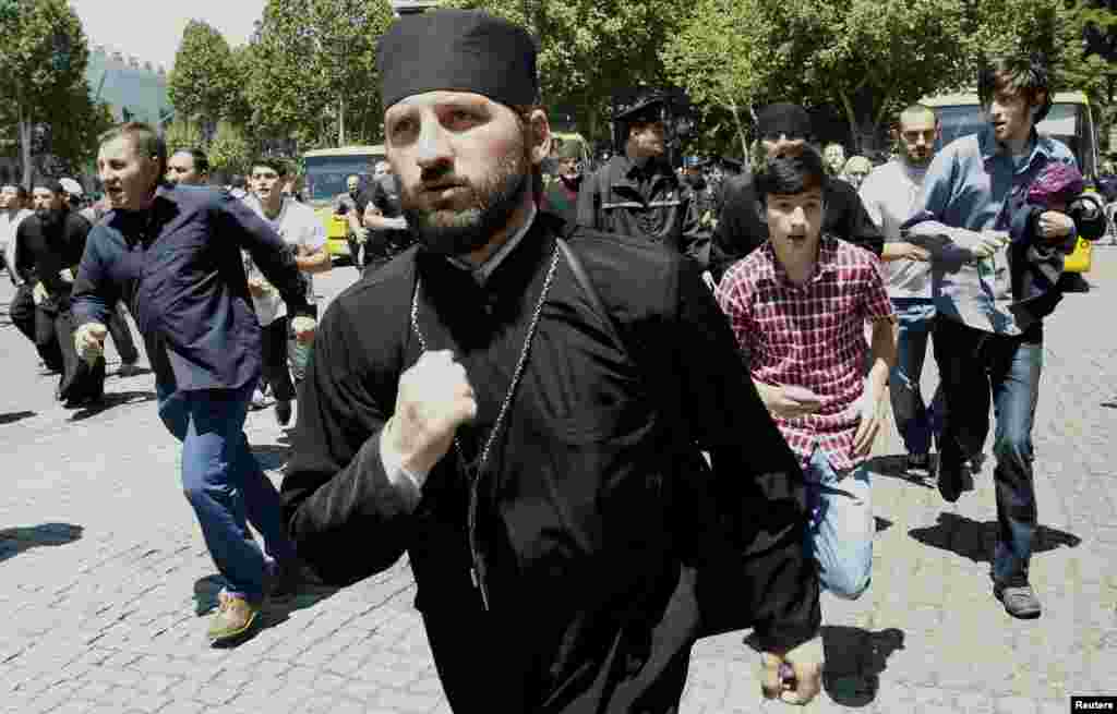 Orthodox Christian activists run during clashes with gay rights activists at an International Day Against Homophobia and Transphobia rally in Tbilisi, May 17, 2013.