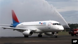 Sebuah truk pemadam kebakaran menyambut kedatangan Sukhoi Superjet 100 dengan menyemprotkan air ke badan pesawat tersebut setibanya di bandara Halim Perdanakusumah, Jakarta (28/2). Satu dari 12 armada Sukhoi Superjet 100 milik maskapai Sky Aviation telah tiba di Indonesia, sembilan bulan pasca jatuhnya pesawat jenis ini di gunung Salak.