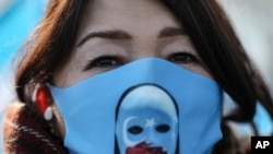 Seorang pengunjuk rasa dari komunitas Uyghur, Kamis, 25 Maret. (Foto: AP)