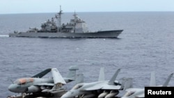 Armada jet tempur AS parkir di dek kapal induk USS George Washington, saat kapal USS Cowpens melintas di Laut China Selatan, September 2010 (Foto: dok).
