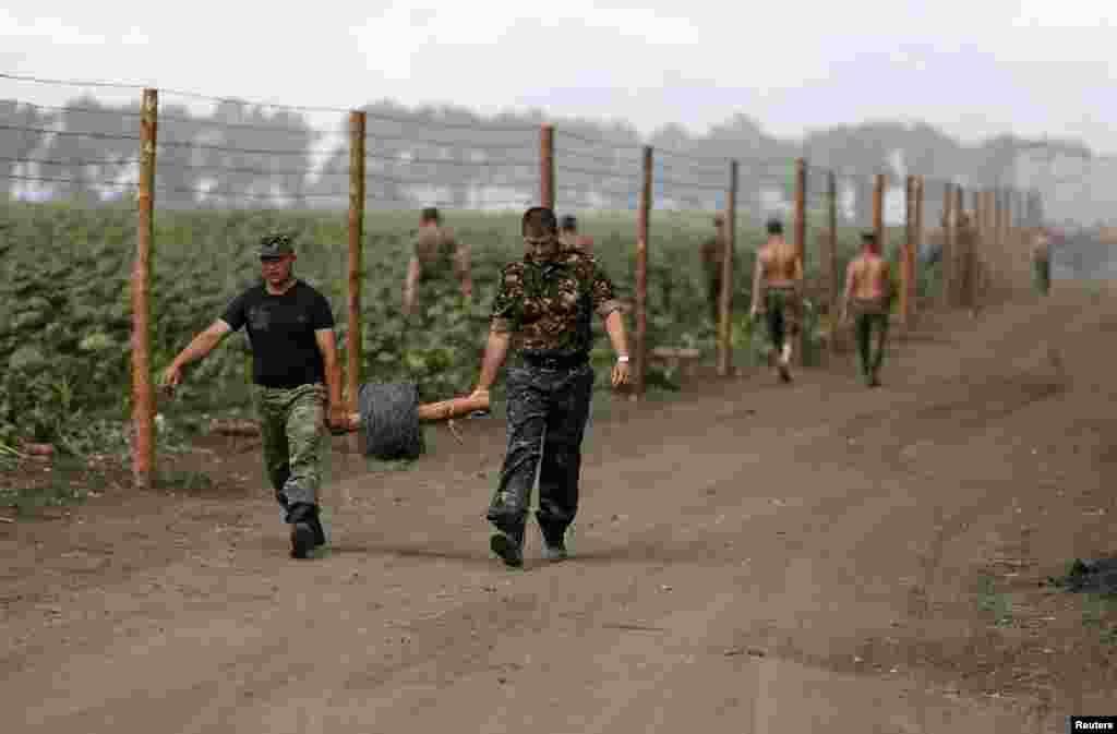 Ukrainian soldiers set up a barbed wire fence at a temporary base near the city of Slovyansk, July 6, 2014.