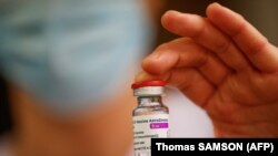 Seorang anggota staf medis memegang botol vaksin AstraZeneca-Oxford pada 8 Februari 2021. (Foto: AFP/Thomas Samson)