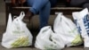 Tas-tas plastik penuh barang belanjaan dari supermarket diletakkan di lantai oleh seorang pembeli di London, 4 Juni 2014. (Foto: dok). Coles, salah satu jaringan supermarket di Australia, menuai kecaman dari para pecinta lingkungan karena membatalkan keputusan yang seharusnya menghentikan penyediaan kantong plastik kepada para pelanggannya.