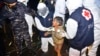 FILE - Medical workers help a Rohingya young girl upon arrival at Krueng Geukueh Port in North Aceh, Indonesia, Dec. 31, 2021.