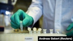 Un employé de la société biopharmaceutique allemande CureVac fait une démonstration de la recherche sur un vaccin contre la maladie à coronavirus (COVID-19) dans un laboratoire de Tübingen, en Allemagne, le 12 mars 2020. REUTERS/Andreas Gebert