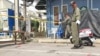 A Thai soldier with a sniffer dog walks near Erawan Shrine, a popular tourist destination that was the site of a bomb attack almost one year ago, in Bangkok on August 12, 2016.