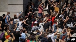 Waandamanaji baadhi yao wakiwa wamepiga magoti katika uwanja wa Trafalgar Square mjini London Jumapili, Mei 31, 2020, kulaani kilo cha George Floyd, Mmarekani mweusi aliyekufa mikononi mwa polisi huko Minneapolis, Minnesota, Marekani. (AP Photo/Matt Dunham).