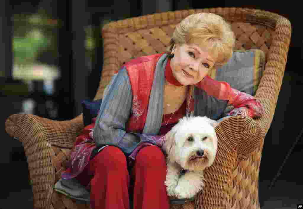 អ្នកស្រី Debbie Reynolds តារាសម្តែងម្នាក់ក្នុងភាពយន្ត «Behind the Candelabra» ថតរូបជាមួយឆ្កែរបស់អ្នកស្រីដែលមានឈ្មោះថា Dwight នៅក្រុង Beverly Hills រដ្ឋកាលីហ្វ័រញ៉ា កាលពីថ្ងៃទី ២១ ឧសភា ឆ្នាំ ២០១៣។ អ្នកស្រីសម្តែងជាតួដែលមានឈ្មោះថា Frances ជាម្តាយរបស់អ្នកលេងព្យ៉ាណូនិងអ្នកចម្រៀងលោក Liberace។