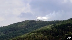A grab from video provided by Russian Emergency Ministry, shows a Russian Emergency Ministry's Beriev plane BE-200 Be-200 multipurpose amphibious aircraft releasing water in the Trans-Baikal National Park in Buryatia, southern Siberia, July 10, 2020.