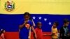 Un grupo de niños juega en las calles, frente a una bandera de Venezuela. Imagen de archivo del 7 de septiembre de 2019.