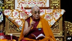 FILE - The Dalai Lama delivers his message as he attends a fair in Milan, Italy, Oct. 21, 2016.