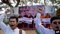 Para pendeta Buddha Myanmar memegang spanduk sementara para demonstran berunjuk rasa di Rangoon, Myanmar (29/12). Mereka meneriakkan protes dan menuntut pembebasan dua pekerja migran yang dijatuhi hukuman mati di Thailand.