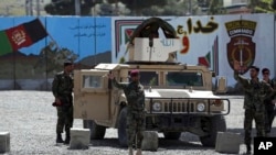 FILE - Afghan special forces stand guard near the site of a suicide bomb attack on the outskirts of Kabul, Afghanistan, April 29, 2020. 