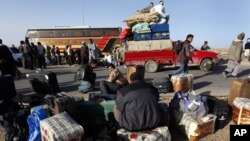 Des Egyptiens de retour de Libye attendant leurs bagages à la frontière