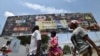 Quelques personnes marchent devant une pancarte publicitaire géante du Marché des Arts du Spectacle Africain d'Abidjan (Masa), à Abidjan, le 9 mars 2018.