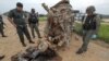 FILE - Military personnel stand next to a damaged military vehicle where soldiers were attacked by suspected Muslim militants at Muang district in the southern province of Yala, Thailand, Sept. 4, 2015. 