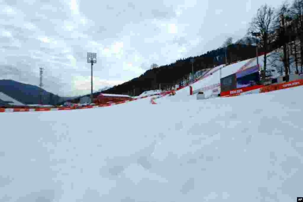 Soft tufts of snow protrude the surface in the finish area of the alpine ski course at the Sochi 2014 Winter Olympics. Warm temperatures in the mountains made the snow too soft and caused the cancellation of women's downhill training, Krasnaya Polyana, Russia, Feb. 11, 2014.