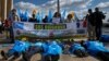 FILE - Supporters of the French Uyghur Community shout slogans and hold Uyghur flags during a demonstration over China's human rights record near the Eiffel Tower on March 25, 2019.
