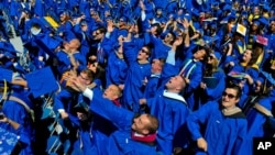 Graduates throw their caps in the air in triumph at the University of Delaware's commencement ceremony in Newark, Del., Saturday, May 31, 2014. (AP Photo/Emily Varisco)
