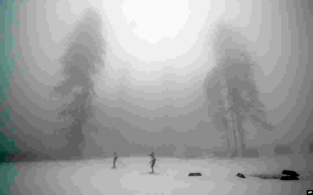 Para atlit biathlon 15K berlatih di tengah-tengah kabut, 17 Februari 2014. 