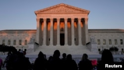 FILE - People gather to mourn the death of Associate Justice Ruth Bader Ginsburg at the Supreme Court in Washington, U.S., Sept. 20, 2020.