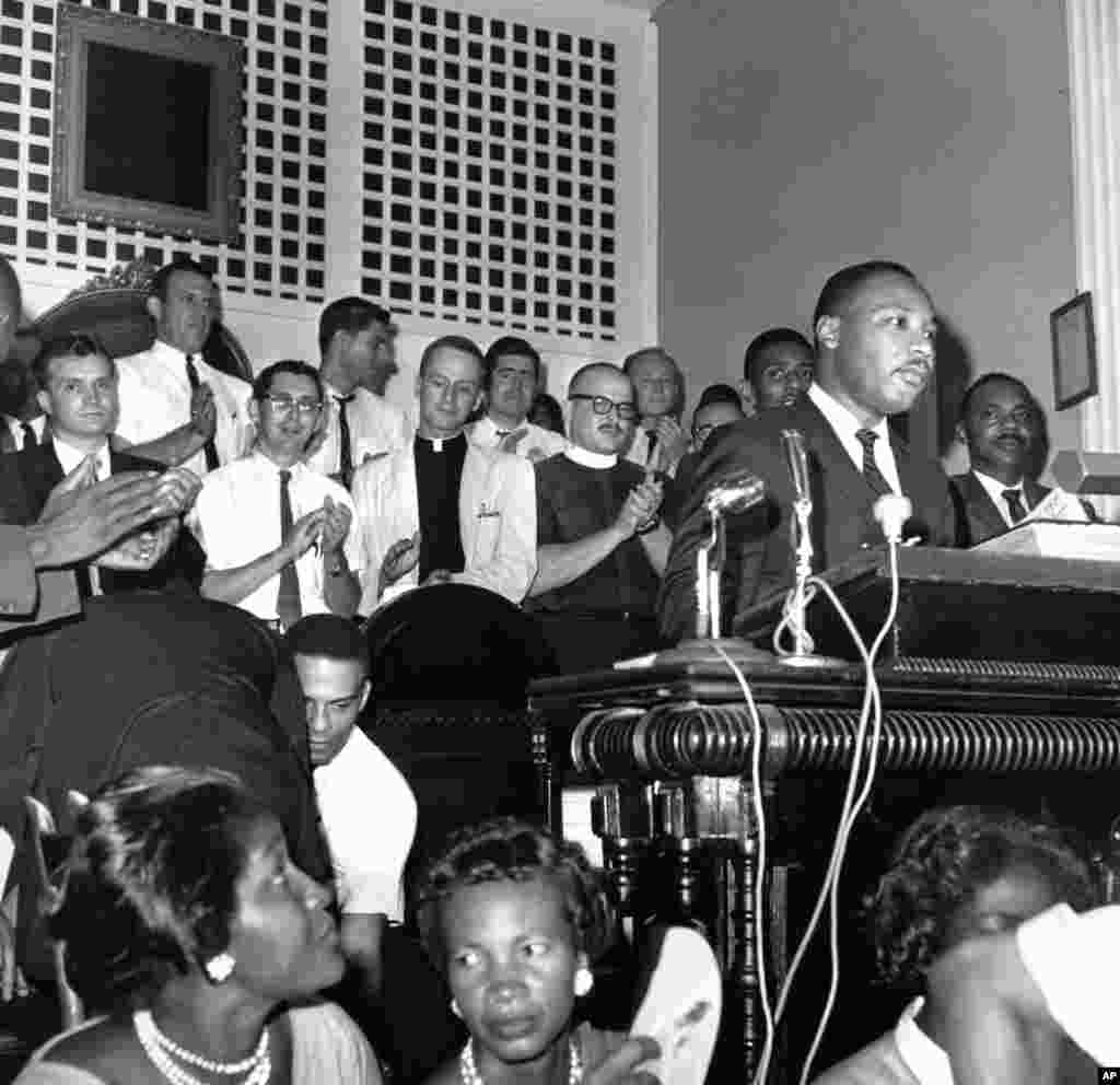Sekelompok pendeta dari negara bagian-negara bagian utara bertepuk tangan menanggapi pidato presiden Konferensi Kepemimpinan Kristen Selatan Martin Luther King Jr. di sebuah gereja di Albany, Georgia, 28 Agustus 1962.