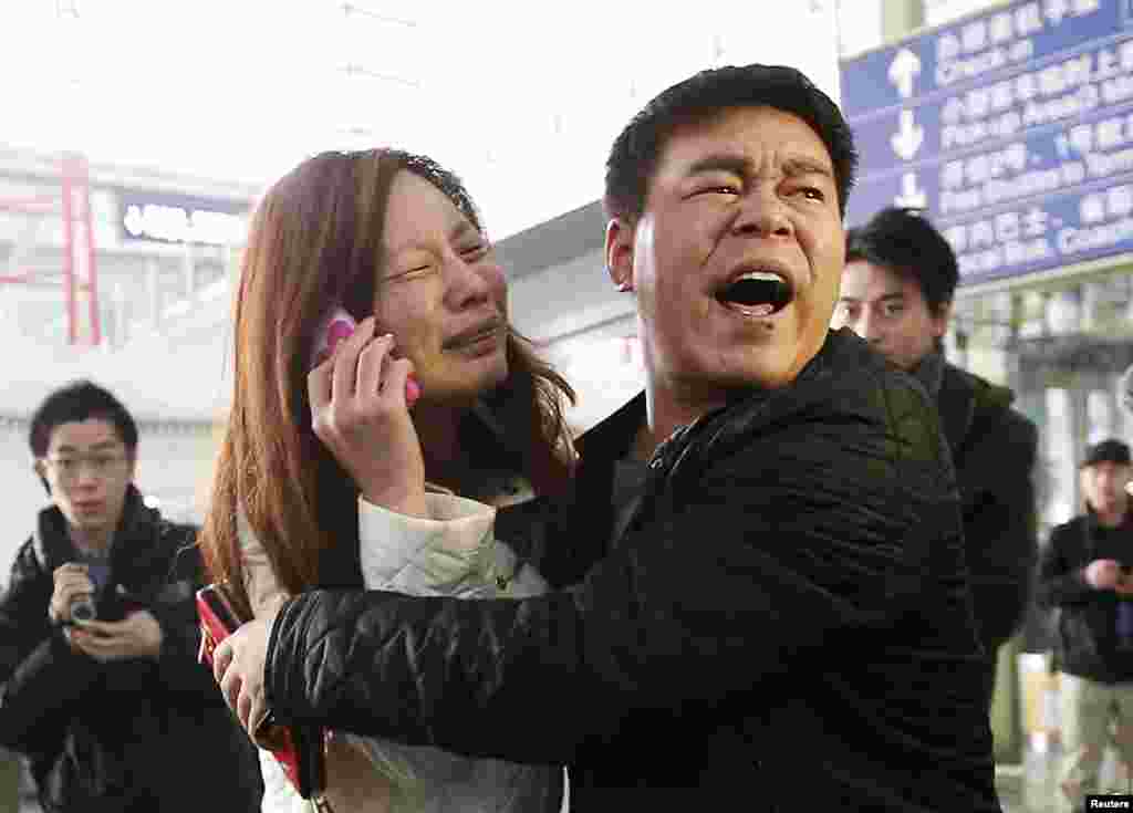 A relative of a passenger onboard Malaysia Airlines flight MH370 cries as she talks on her mobile phone at the Beijing Capital International Airport, China.
