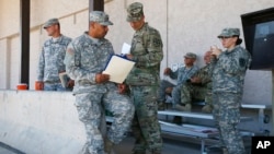 Soldados de la Guardia Nacional de Arizona reciben sus notificaciones previo a su despliegue en la frontera con México, el 9 de abril, de 2018, en Phoenix, Arizona.