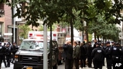 Oficiales de la policía de la ciudad de Nueva York responden a la escena de un paquete sospechoso en una instalación postal, el viernes 26 de octubre de 2018 en Nueva York.