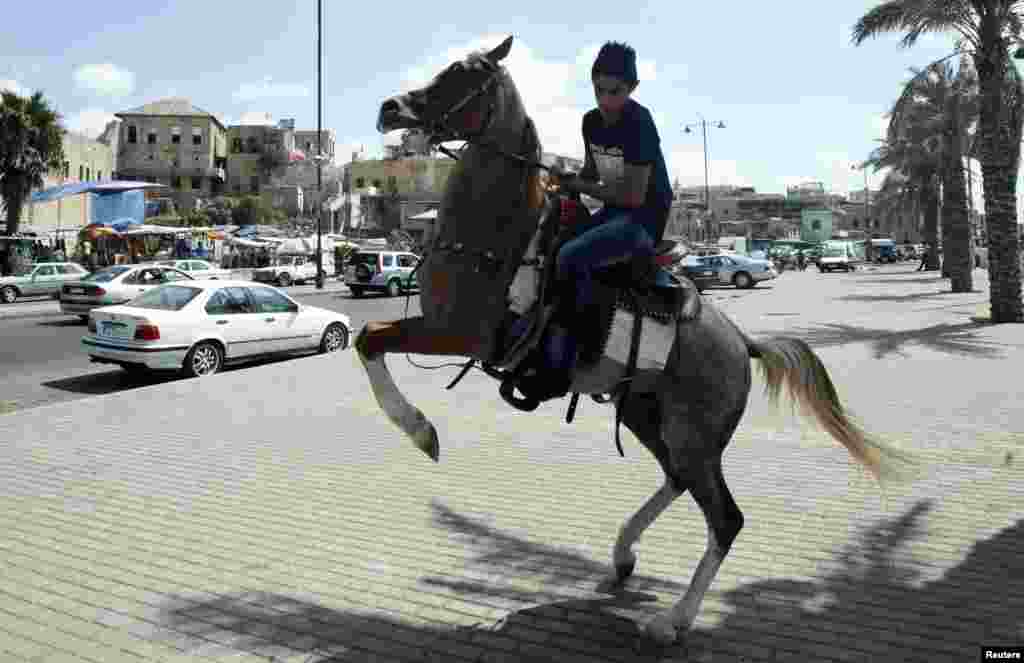 A youth rides a rented horse as he celebrates Eid al-Fitr in the port city of Sidon, southern Lebanon, August 8, 2013. 