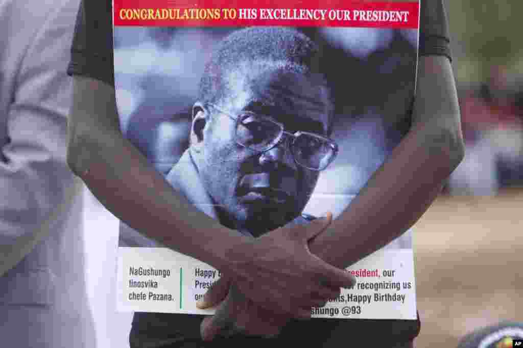 Un partisan du président zimbabwéen Robert Mugabe tient le portrait de celui-ci lors des célébrations du 93e anniversaire de celui-ci à Matopos, dans la banlieue de Bulawayo, 25 février 2017.