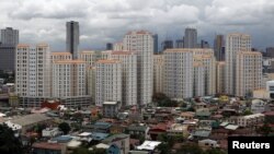 FILE - Rows of condominium buildings are seen behind a middle-class residential district in Mandaluyong, Metro Manila. The economy grew 6.4 percent in the first three months of the year, second only to China, July 4, 2012.