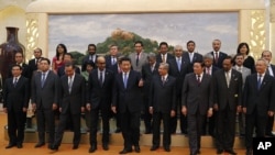 FILE - Chinese President Xi Jinping, center, shows the way to the guests who attended the signing ceremony of the Asian Infrastructure Investment Bank at the Great Hall of the People in Beijing, Oct. 24, 2014.