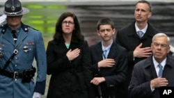 The family of Martin Richard, from left, mother Denise, brother Henry, and father Bill Richard, with former Boston Mayor Tom Menino, right, during a tribute in honor of the one year anniversary of the Boston Marathon bombings, Apr. 5, 2014, in Boston. 