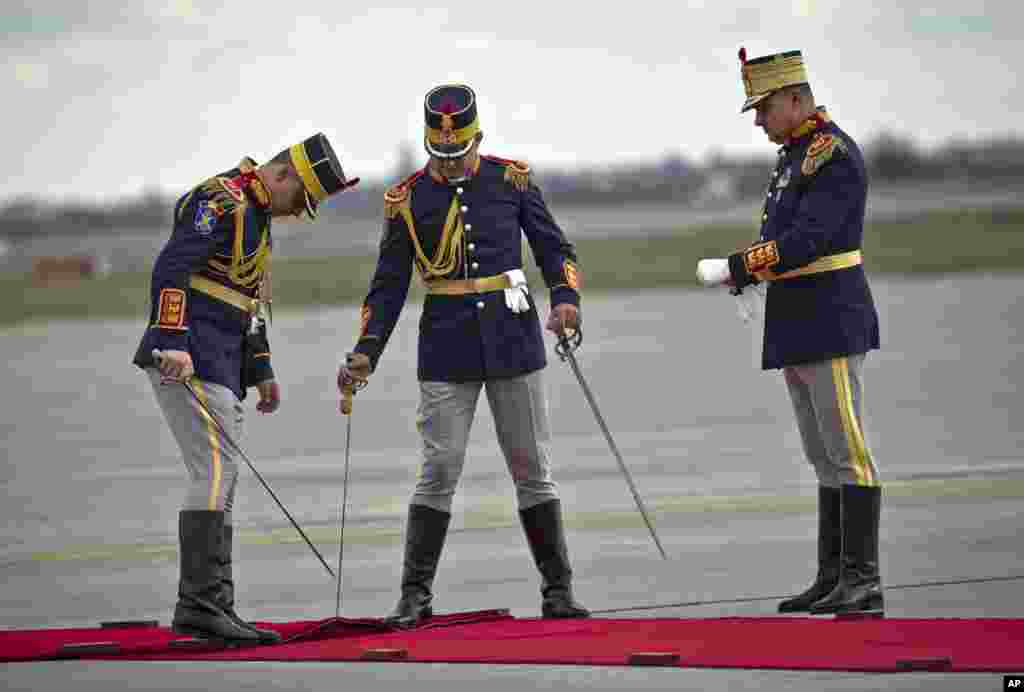Honor guard soldiers position a red carpet before the arrival of China's Premier Li Keqiang at the Henri Coanda airport, outside Bucharest, Romania.