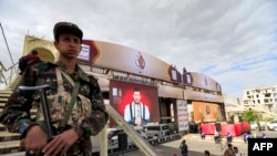 Pejuang yang setia kepada Houthi Yaman berjaga-jaga sementara para pendukung pemberontak yang didukung Iran menghadiri pidato virtual Abdulmalik al-Huthi pemimpin kelompok itu di ibu kota Sanaa, Yaman, 2 September 2021. (Mohammed HUWAIS / AFP)