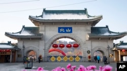 Turis berjalan melewati gerbang yang disebut "Beishan" di Taman Beishan di provinsi Jilin, China, pada 23 Januari 2020. (Foto: Zhu Wanchang/CNS Photos via AP)