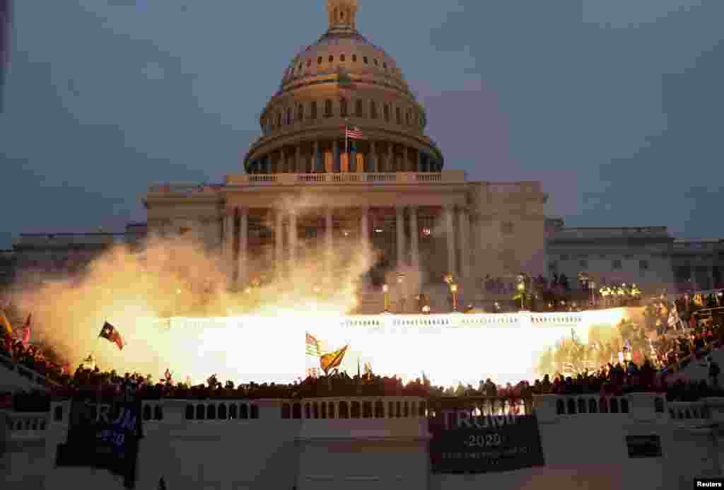 Uma explosão causada por uma munição policial é vista enquanto apoiantes do Presidente dos EUA, Donald Trump, se reúnem em frente ao edifício do Capitólio dos EUA em Washington, 6 de Janeiro de 2021.