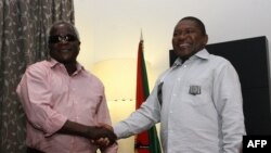 Le leader de l'opposition Afonso Dhlakama, à gauche, serre la main du président mozambicain Filipe Nyusi, à droite, à Maputo, Mozambique, 7 février 2015