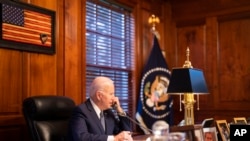 In this image provided by The White House, President Joe Biden speaks with Russian President Vladimir Putin on the phone from his private residence in Wilmington, Del., Thursday, Dec. 30, 2021. (Adam Schultz/The White House via AP)